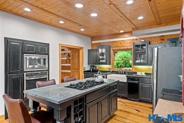 kitchen featuring appliances with stainless steel finishes, wooden ceiling, a sink, and light wood-style floors