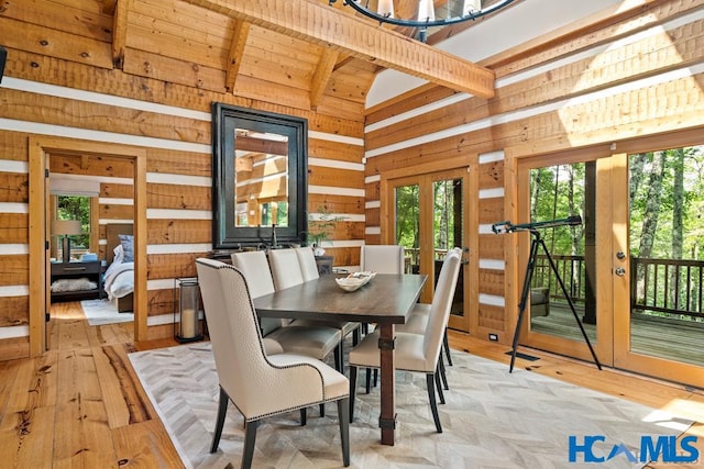 dining room featuring lofted ceiling with beams, wood walls, wood ceiling, and light wood finished floors