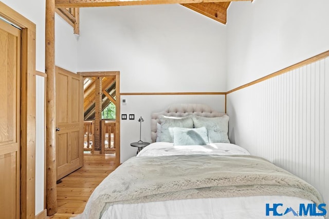 bedroom featuring light wood-style flooring and high vaulted ceiling