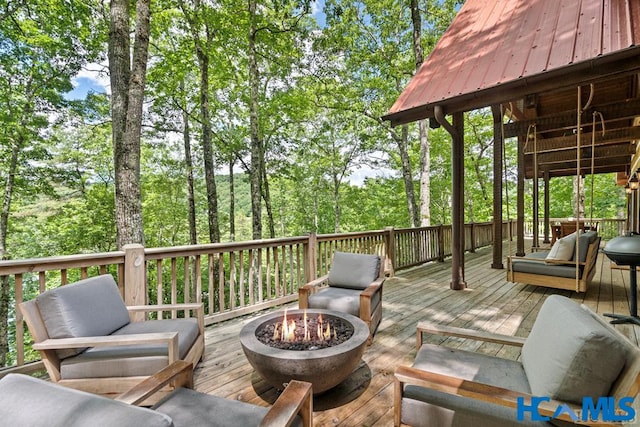 wooden deck featuring an outdoor living space with a fire pit