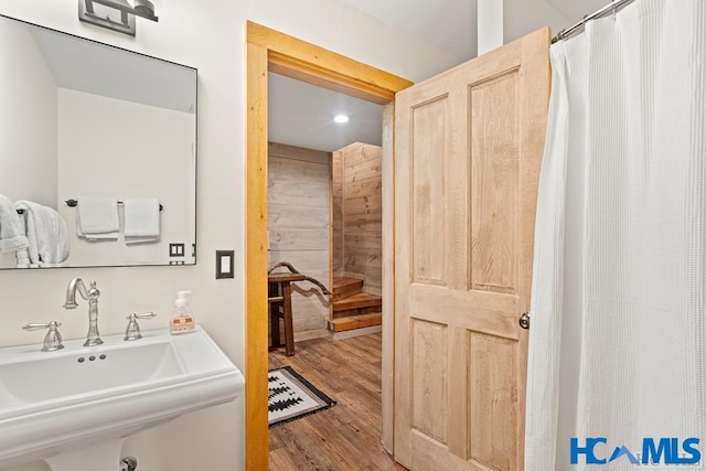 full bath with wood finished floors and a sink