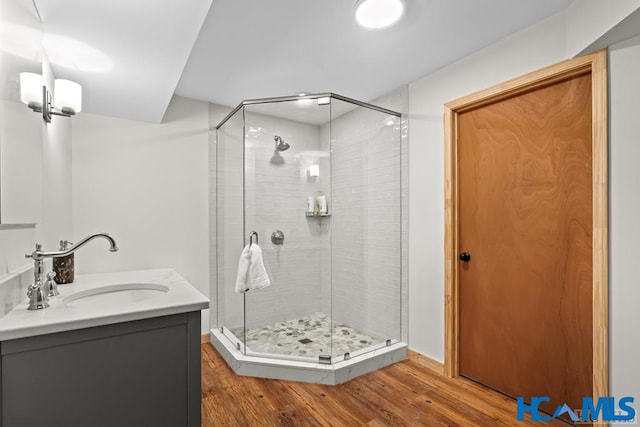 full bath featuring a stall shower, wood finished floors, and vanity