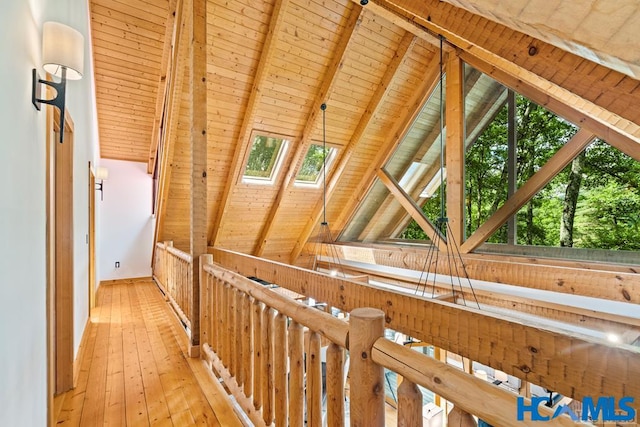 corridor featuring vaulted ceiling with skylight, wooden ceiling, and light wood-style flooring