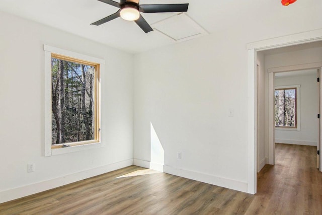 empty room with ceiling fan, baseboards, and wood finished floors