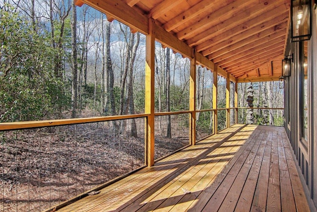 unfurnished sunroom featuring lofted ceiling with beams