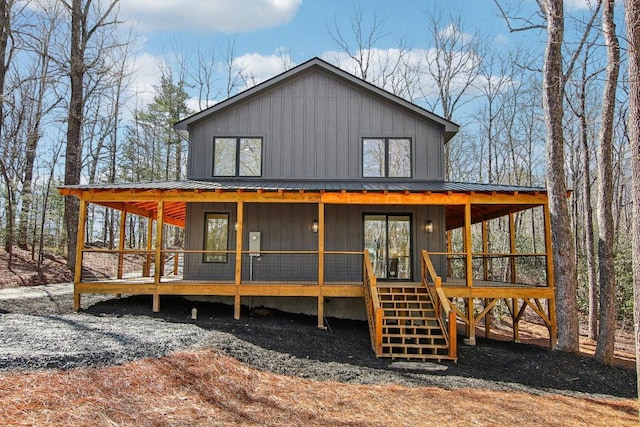 view of front of home with stairs, metal roof, and board and batten siding