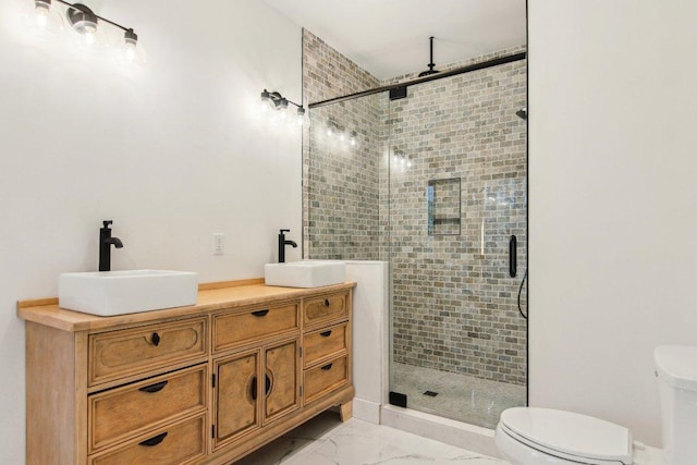 bathroom with marble finish floor, double vanity, a stall shower, and a sink