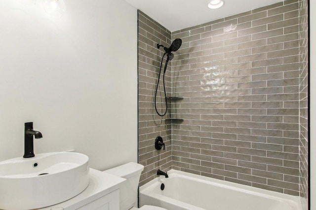 bathroom with washtub / shower combination, a sink, and toilet