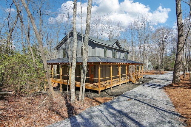 exterior space with driveway, a sunroom, and board and batten siding