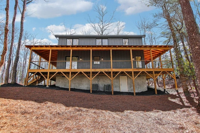 rear view of house featuring central air condition unit, a deck, and board and batten siding