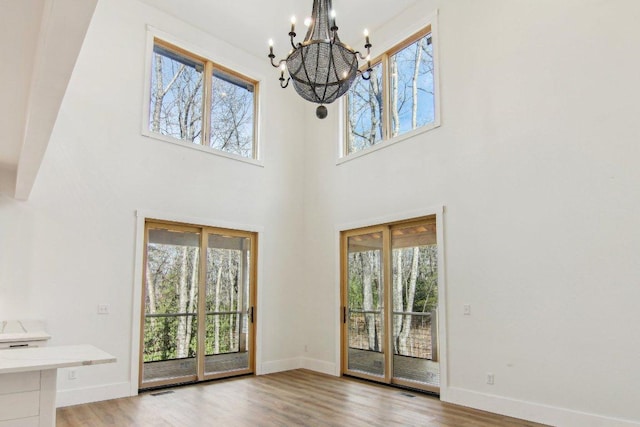 interior space with a wealth of natural light, baseboards, and wood finished floors