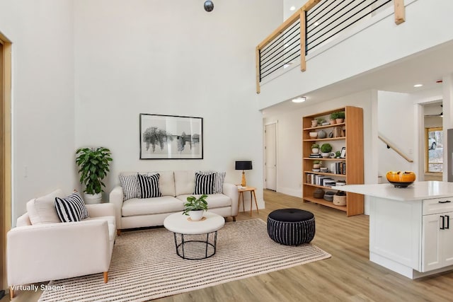 living room featuring a high ceiling and light wood-type flooring