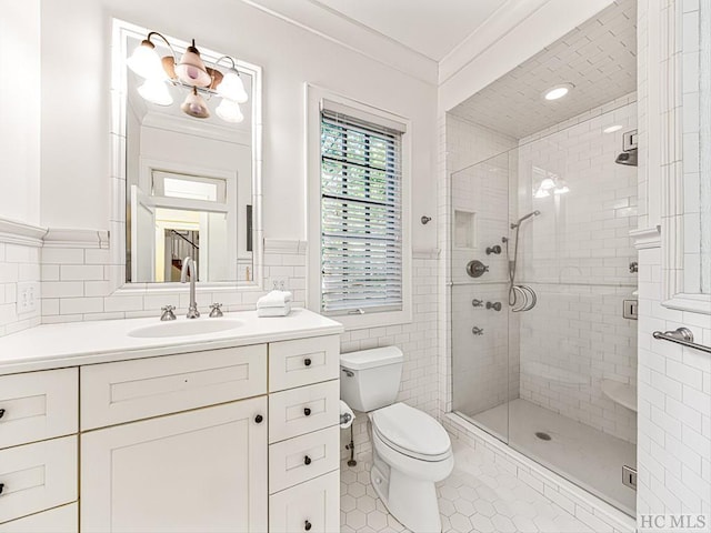 bathroom with toilet, tile walls, vanity, walk in shower, and crown molding