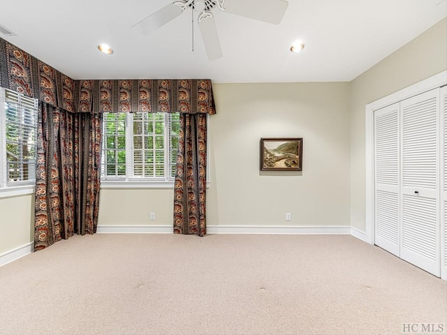 carpeted spare room featuring ceiling fan