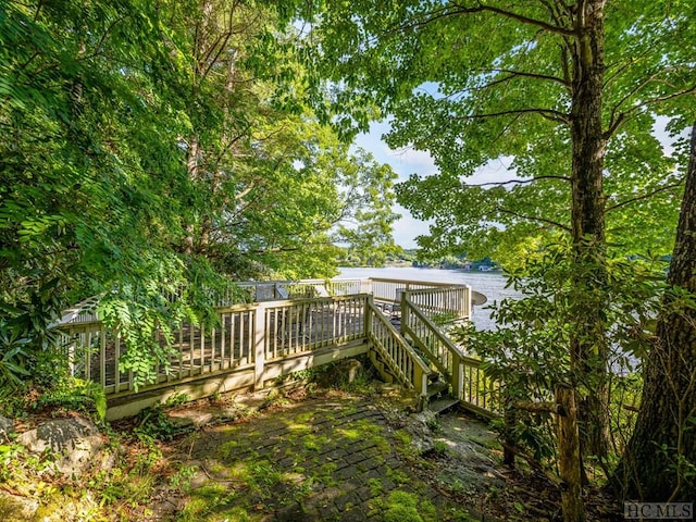 view of yard with a deck with water view