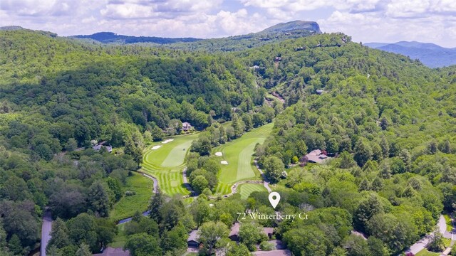 72 Winterberry Ct Unit 7, Highlands, NC 28741 - aerial overview of property's location with a heavily wooded area and a mountain backdrop