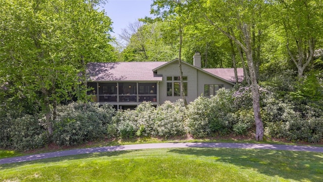 72 Winterberry Ct Unit 7, Highlands, NC 28741 - back of property featuring a sunroom, roof with shingles, a chimney, and a yard
