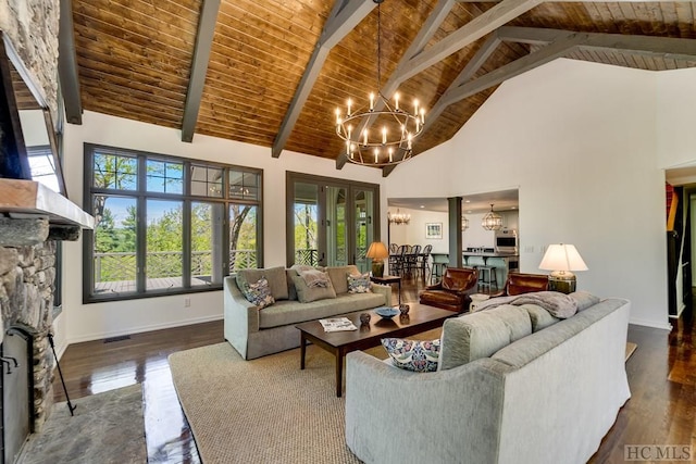 living room with high vaulted ceiling, dark hardwood / wood-style floors, a notable chandelier, a stone fireplace, and beamed ceiling