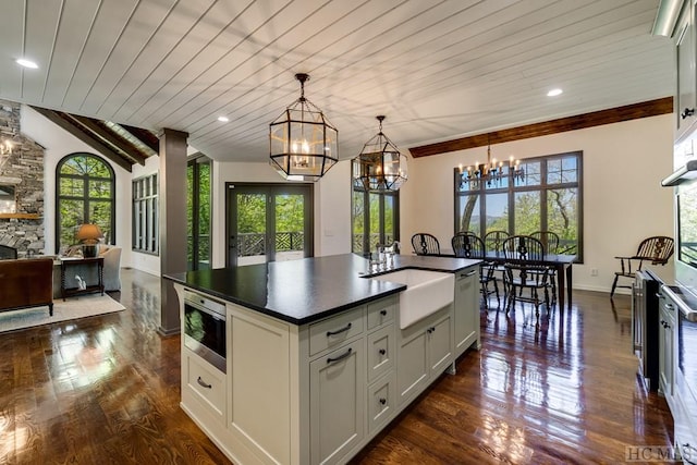 kitchen featuring white cabinetry, decorative light fixtures, and wooden ceiling