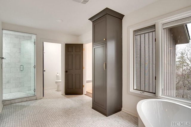 bathroom featuring tile patterned floors, plus walk in shower, and toilet