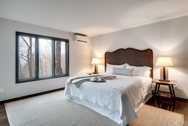 bedroom featuring hardwood / wood-style flooring and an AC wall unit