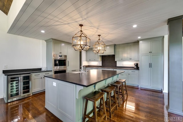 kitchen with dark wood-type flooring, sink, decorative light fixtures, beverage cooler, and decorative backsplash