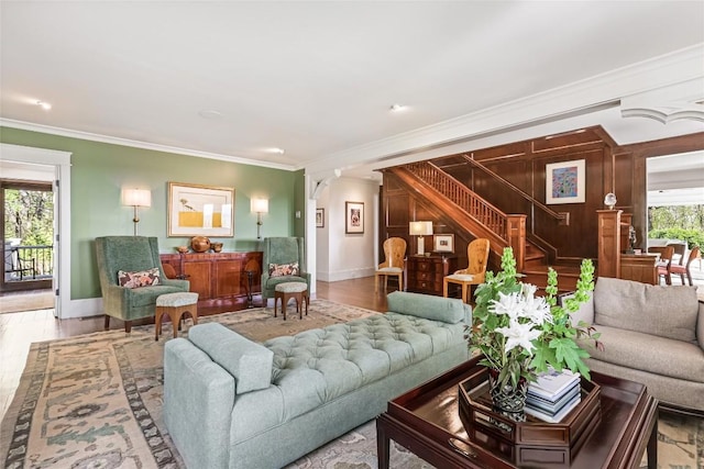 living room with stairway, crown molding, baseboards, and wood finished floors