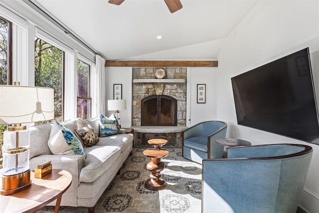 living room with vaulted ceiling, ceiling fan, and a stone fireplace