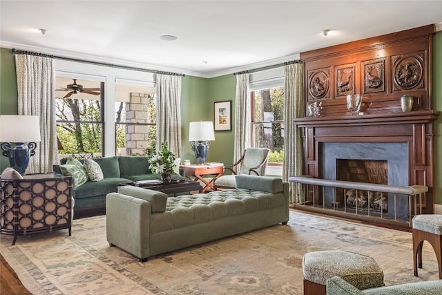living room with a fireplace, ornamental molding, wood finished floors, and ceiling fan