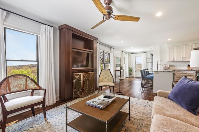 living area featuring dark wood-style floors, ceiling fan, and recessed lighting