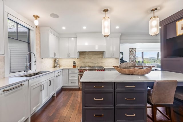 kitchen featuring a sink, white cabinets, high end range, decorative backsplash, and dark wood-type flooring