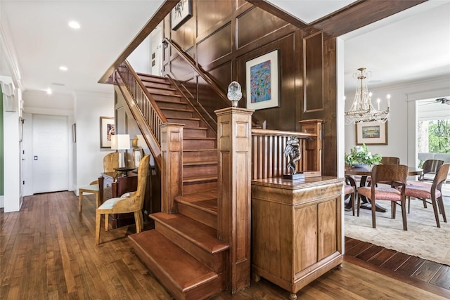 stairs featuring ornamental molding, hardwood / wood-style floors, a chandelier, and recessed lighting
