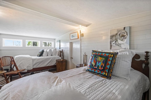 bedroom featuring wooden walls and a textured ceiling
