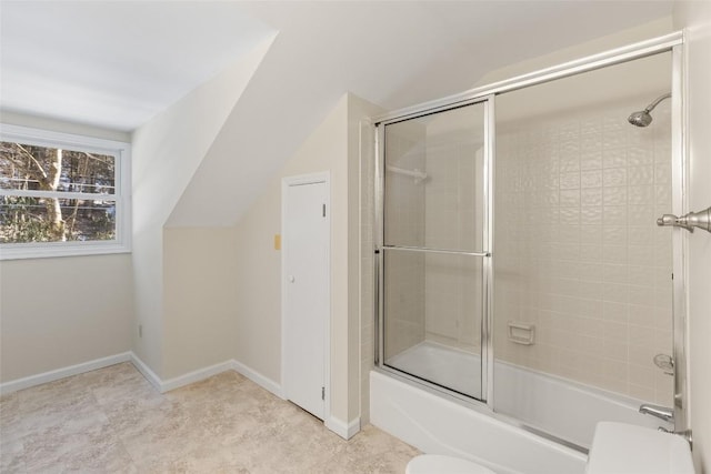 bathroom featuring bath / shower combo with glass door, lofted ceiling, and toilet