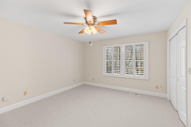 unfurnished bedroom featuring ceiling fan, a closet, and light carpet