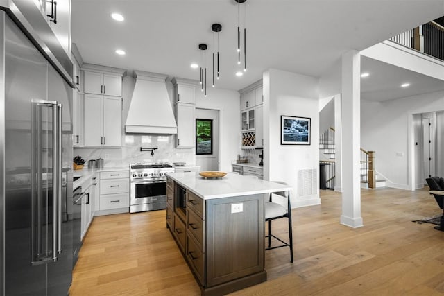 55 Steeplebush Ct, Tuckasegee, NC 28783 - kitchen featuring high quality appliances, custom exhaust hood, a breakfast bar, light countertops, and decorative backsplash