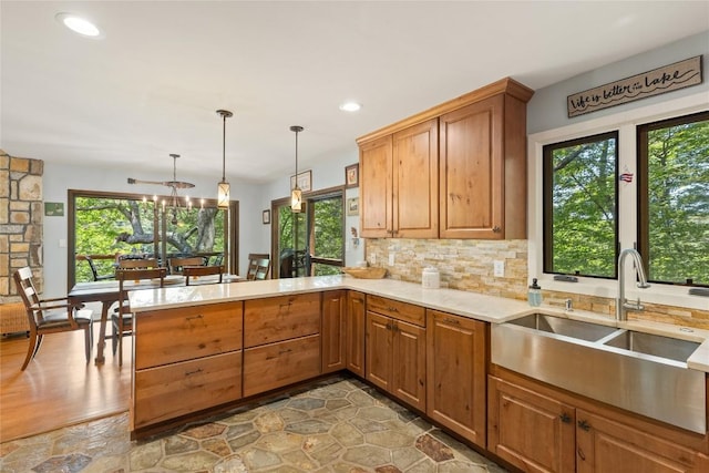230 Jersey Trl Unit 12, Sapphire, NC 28774 - kitchen featuring a peninsula, backsplash, recessed lighting, hanging light fixtures, and brown cabinets