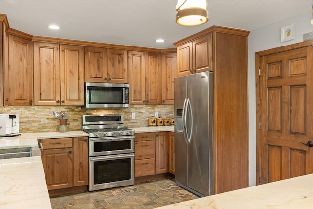 230 Jersey Trl Unit 12, Sapphire, NC 28774 - kitchen featuring stainless steel appliances, tasteful backsplash, brown cabinets, light stone countertops, and recessed lighting