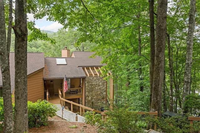 230 Jersey Trl Unit 12, Sapphire, NC 28774 - back of property featuring roof with shingles, a chimney, stone siding, and a forest view