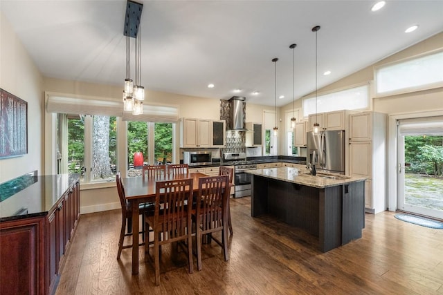 314 Beckonridge Trl, Sapphire, NC 28774 - kitchen featuring stainless steel appliances, wall chimney exhaust hood, an island with sink, dark wood-style floors, and cream cabinetry