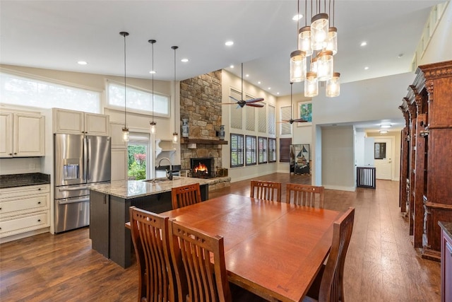 314 Beckonridge Trl, Sapphire, NC 28774 - dining room with a towering ceiling, a fireplace, dark wood-type flooring, ceiling fan, and recessed lighting