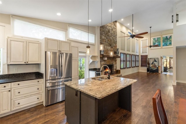 314 Beckonridge Trl, Sapphire, NC 28774 - kitchen with stainless steel refrigerator with ice dispenser, cream cabinets, a ceiling fan, a fireplace, and dark stone countertops