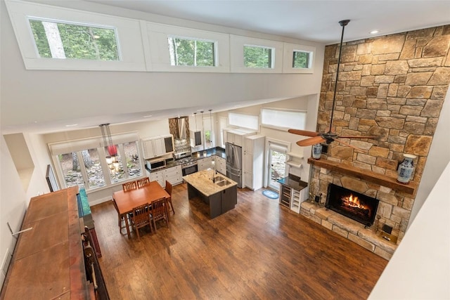 314 Beckonridge Trl, Sapphire, NC 28774 - living area with a ceiling fan, a stone fireplace, dark wood-style flooring, a high ceiling, and recessed lighting