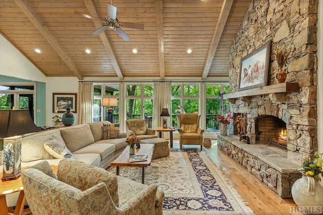 living room featuring a stone fireplace, vaulted ceiling with beams, wood ceiling, light wood-type flooring, and ceiling fan