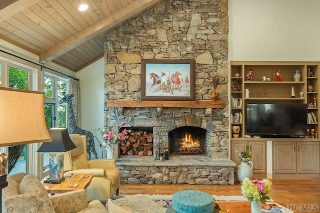 living room featuring wooden ceiling, a stone fireplace, light hardwood / wood-style floors, and vaulted ceiling with beams