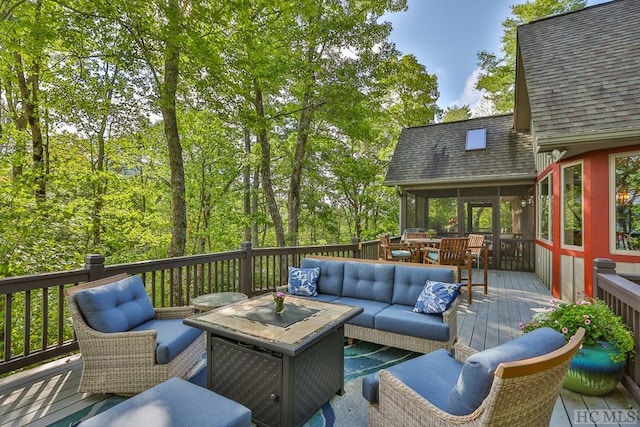 deck with a sunroom and an outdoor living space with a fire pit