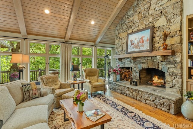 sunroom featuring a healthy amount of sunlight, a fireplace, lofted ceiling with beams, and wooden ceiling