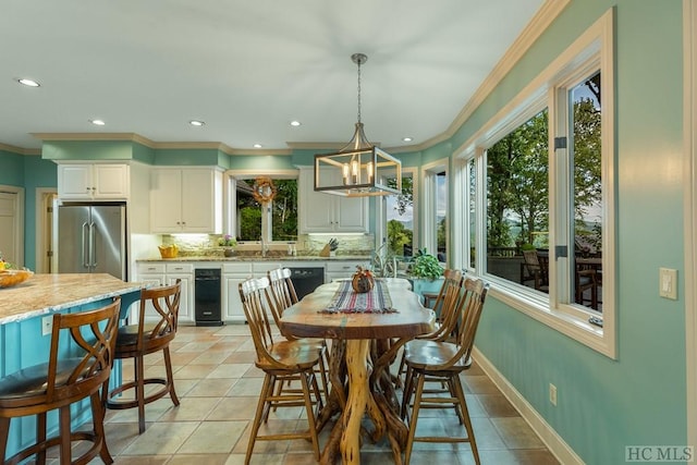 tiled dining space featuring ornamental molding and a chandelier