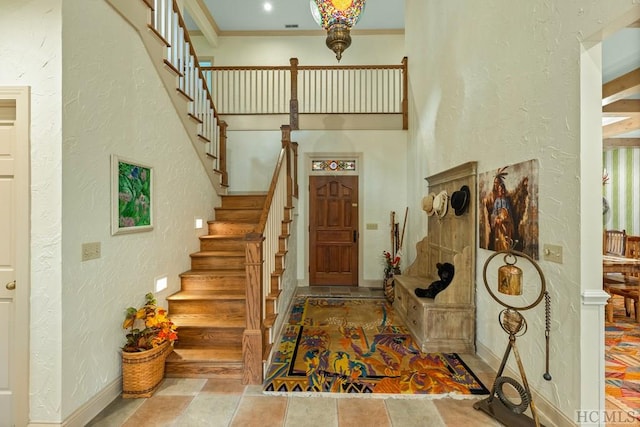 foyer entrance with crown molding and a high ceiling