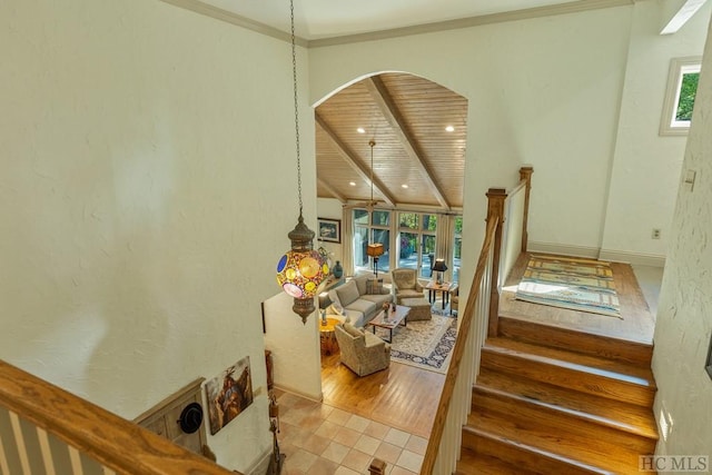 stairs featuring ornamental molding, a wealth of natural light, tile patterned flooring, and wooden ceiling